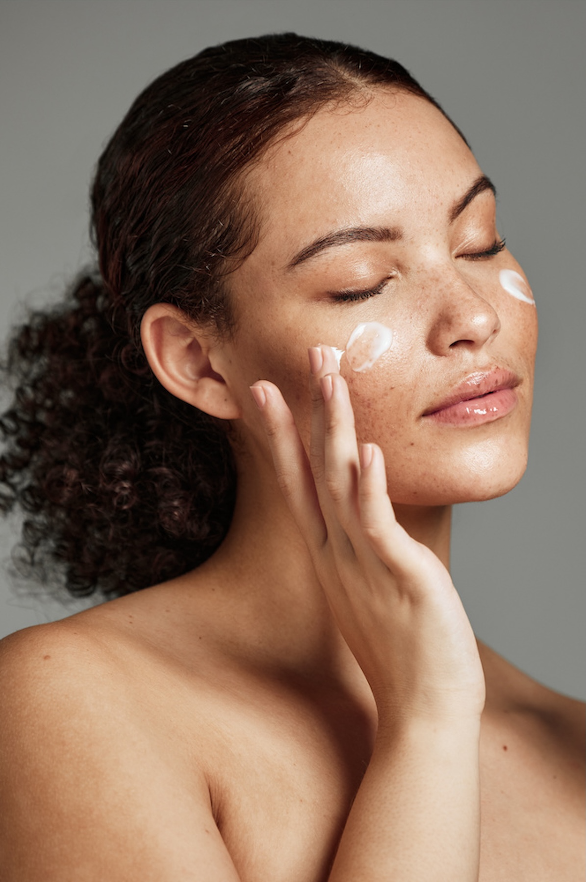 woman applying skincare to her face